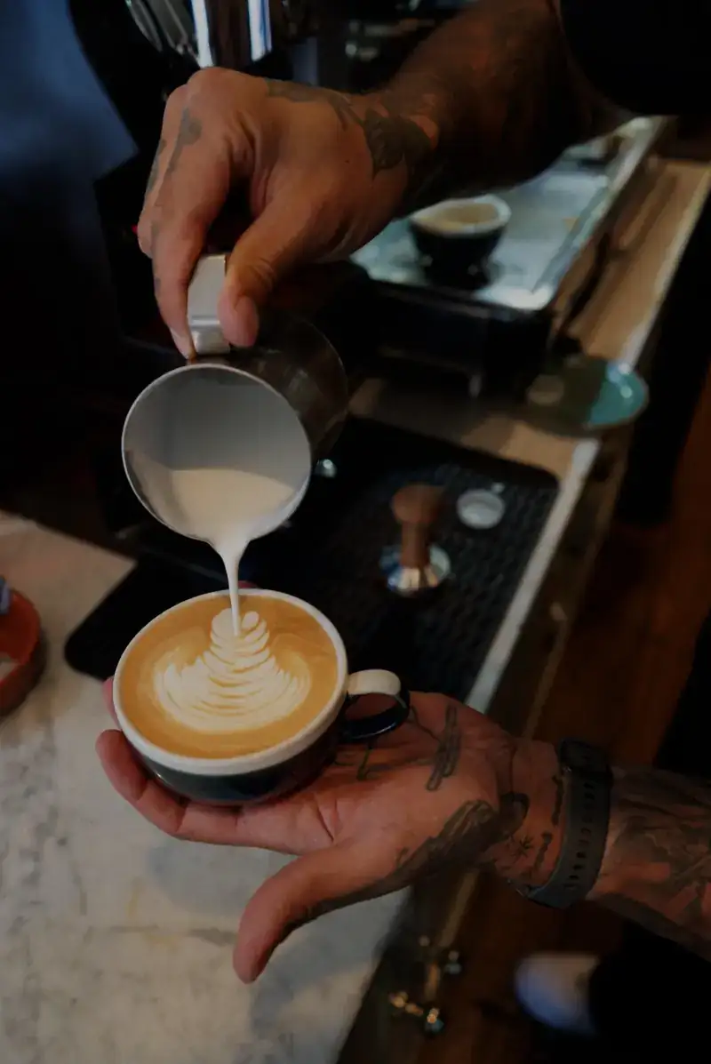 Pouring latte art behind the bar